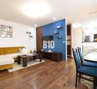 Living room in a three-room apartment with a wooden decor floor and stylish furniture.