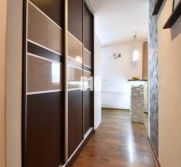 A hallway in a 3-room apartment with a wooden decor floor and a built-in wardrobe.