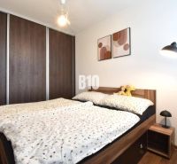 A bedroom in a 3-room apartment with a built-in wardrobe and a bed with a wooden decor.