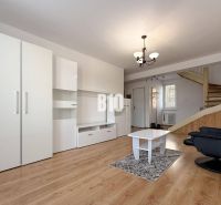 Living room in a holiday apartment with white furniture and a wooden decor floor.