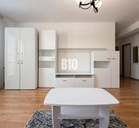 Interior of a holiday apartment with white furniture and a wooden decor floor.