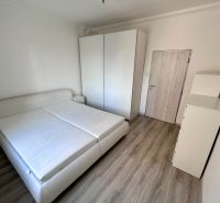 A bedroom in a 3-room apartment with a wooden decor floor and white furniture.