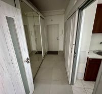 A hallway with tiled flooring and a mirrored wardrobe in a 3-room apartment.