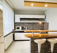 Kitchen in a studio apartment, bright interior, kitchen unit, chairs at the bar.