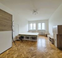 A room of a 3-room apartment with a bed and furniture, floor with wooden decor.