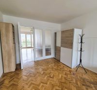 A room in a 3-room apartment with a wooden decor floor and white doors.