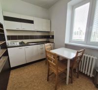 A kitchen with a kitchen unit, table, chairs, and a wood-decor floor in a 3-room apartment.