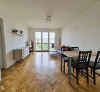 Living room in a 3-room apartment with a wood-patterned floor and a dining table.