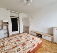 A bedroom with a bed, storage furniture, and a wooden decor floor in a 3-room apartment.