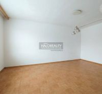 A room in a one-bedroom apartment with white walls and a wooden decor floor.