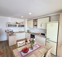 A kitchen with a dining table in a three-room apartment, a floor with a wooden decor.