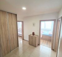 A hallway in a 3-room apartment with adjoining rooms and a floor with a wooden decor.