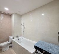 Bathroom in a 3-room apartment with a bathtub, toilet, and washing machine, neutral color appearance.