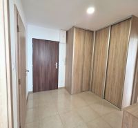 The hallway of a 3-room apartment with ceramic tiles and a built-in wardrobe with a wooden decor.