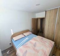 Bedroom in a 3-room apartment with storage space, a double bed, and a wooden decor floor.