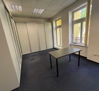 Offices with carpet, white walls, and a desk, large windows.