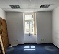 Offices with blue carpet and doors leaning against the wall.