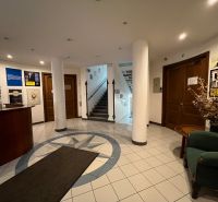 Office interior with staircase, reception, and patterned tile flooring.