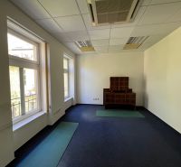 Offices with windows and carpeted floors, with wooden furniture.