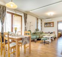 Dining room and living room with wood-patterned flooring in a family house.
