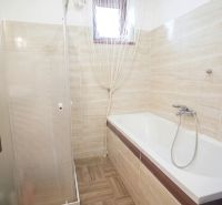 A bathroom in a family house with a bathtub and a shower.