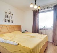 Bedroom in a family house with a bed and brown curtains.