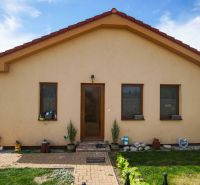 A family house in Andovce with three windows, a yard, and a flower bed.