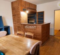 Dining room in a 3-room apartment with a wood-patterned floor and a wooden bar.