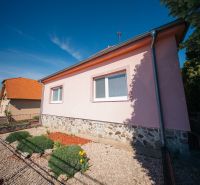 A family house on the street in Golianovo with a stone foundation and a garden lawn.