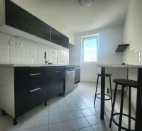 A kitchen in a 3-room apartment with white tiles and dark cabinets.