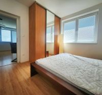 Bedroom with a large wardrobe and bed, wooden decor flooring in a 3-room apartment.