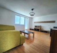 Living room with a sofa, table, and wooden decor flooring in a 3-room apartment.