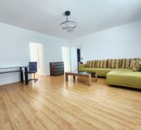 Living room with a sofa, table, and wooden decor flooring in a 3-room apartment.