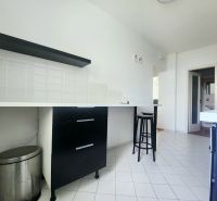 A kitchen with white tiles, black furniture, and a bar stool in a 3-room apartment.