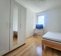 A bright room with a bed, a white wardrobe, and a television, a 3-room apartment, floor with wood decor.