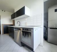 A kitchen with white tiles, a stainless steel dishwasher, and a refrigerator in a 3-room apartment.