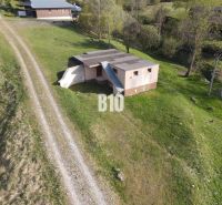 A cottage in Zázrivá surrounded by green countryside and a dirt road.