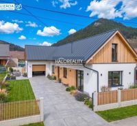 A family house in Stupno with a garage, a well-maintained garden, and wooden cladding on the facade.