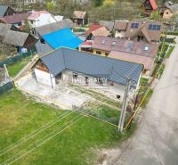 A family house in Stupno with a low blue roof profile, surrounded by neighboring buildings.