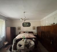 A bedroom in a family house with a bed, wardrobes, and curtains.