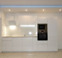 White kitchen unit with an oven and microwave in a 2-room apartment.