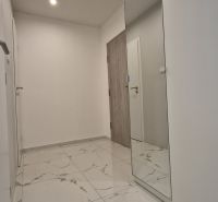 A hallway in a 2-room apartment with a marble floor and a large mirror.