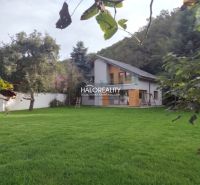 A family house in Poltár surrounded by a lawn and trees, ideal for relaxation.