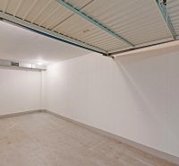 Empty garages with white walls and concrete floors.