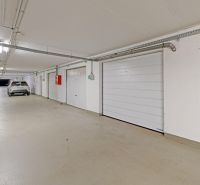 Underground garages with cars in Bratislava - Petržalka, white walls, closed doors.