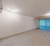 Spacious garages with white walls and a garage door in Bratislava - Petržalka.