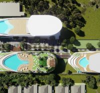 Aerial view of apartment construction in Phuket with rooftop pools and greenery.