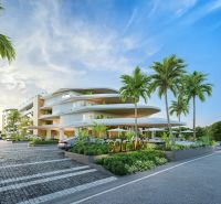 Apartment construction in Phuket with modern architecture, surrounded by palm trees and parking space.