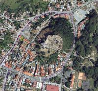Aerial view of plots in the historical center of Fiľakovo, surrounded by buildings and greenery.