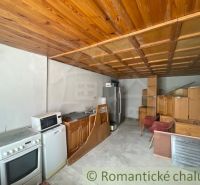 A kitchen in a family house with a wooden ceiling and a kitchen unit.